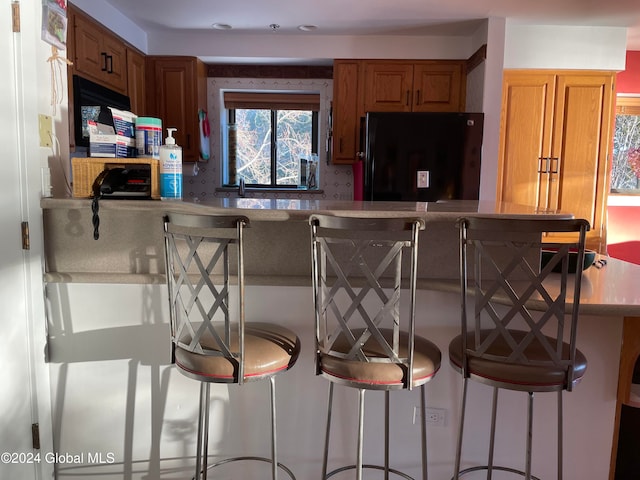 kitchen featuring a kitchen breakfast bar and black fridge