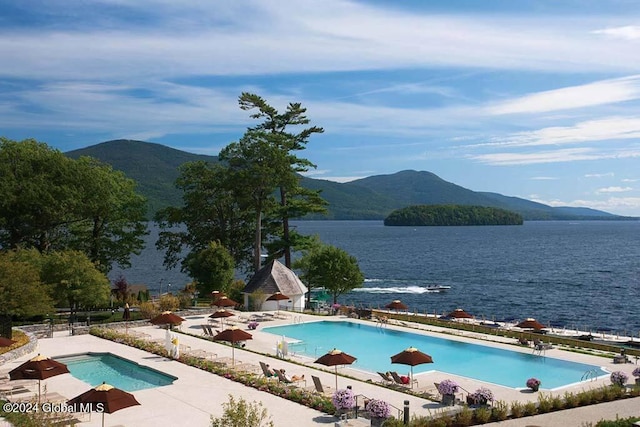 view of swimming pool featuring a water and mountain view