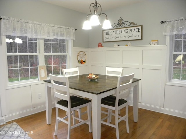 dining space featuring hardwood / wood-style floors and an inviting chandelier