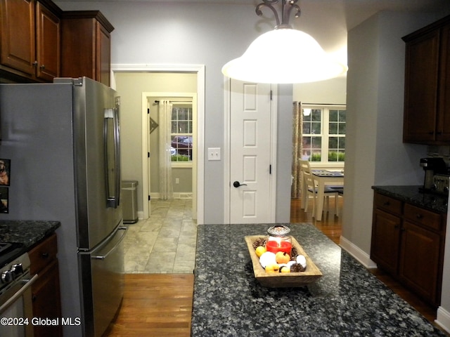 kitchen featuring light hardwood / wood-style floors, appliances with stainless steel finishes, and dark stone counters