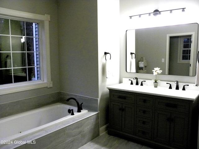 bathroom featuring vanity and tiled tub