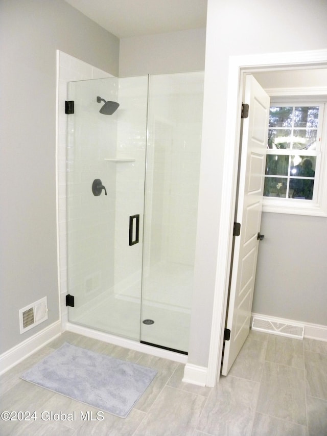 bathroom featuring a shower with shower door