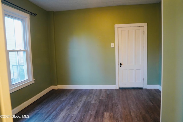 spare room featuring dark hardwood / wood-style flooring and a textured ceiling