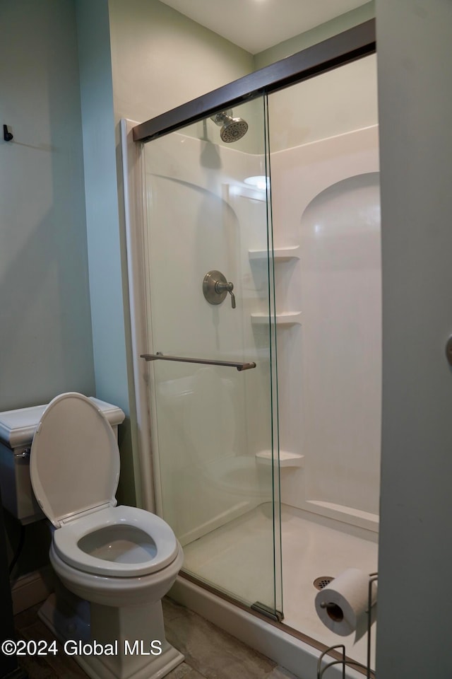 bathroom featuring walk in shower and toilet