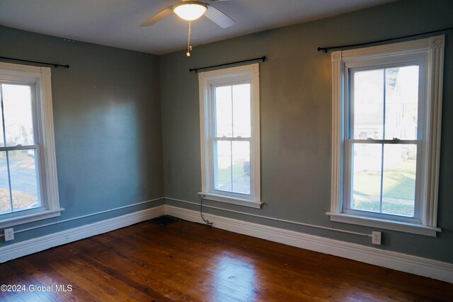 empty room with dark wood-type flooring and ceiling fan