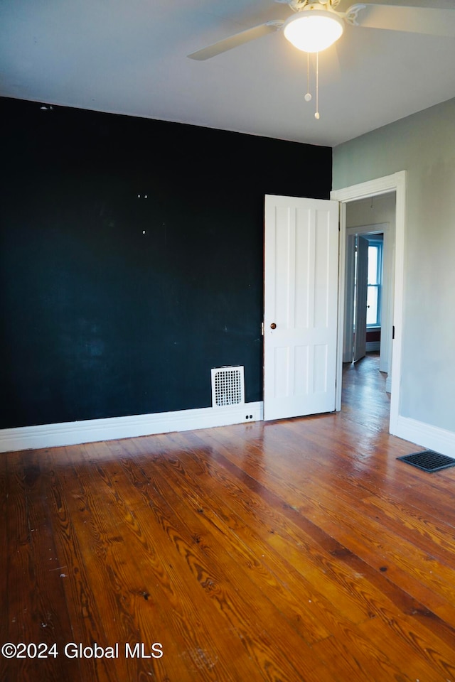 spare room with hardwood / wood-style floors and ceiling fan