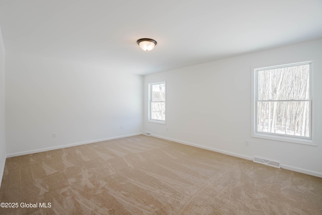 spare room featuring light colored carpet