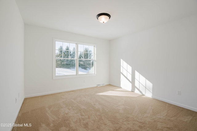 spare room featuring light carpet