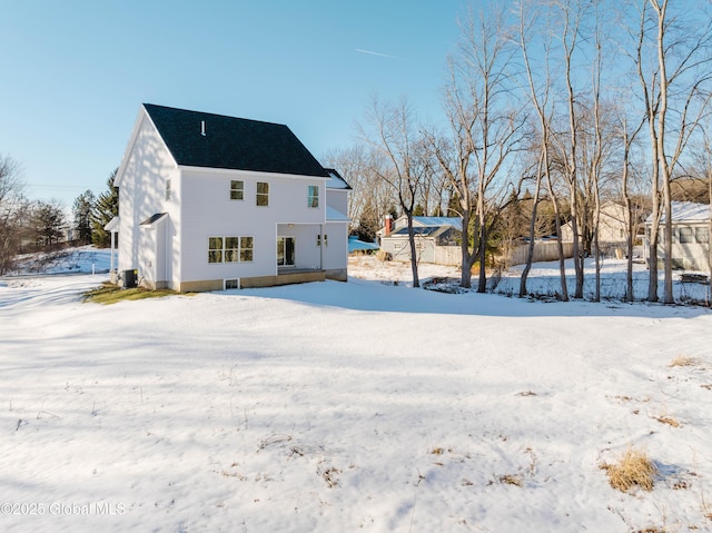 view of snow covered rear of property