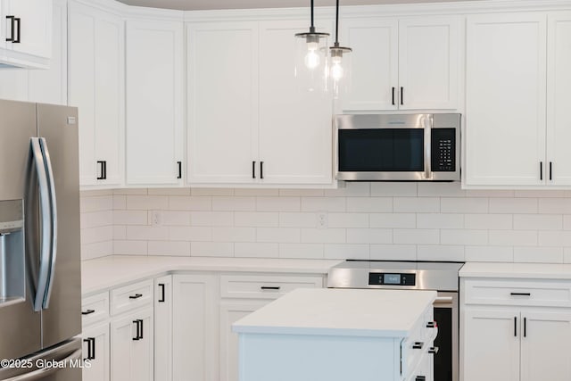 kitchen with white cabinetry, stainless steel appliances, decorative light fixtures, and tasteful backsplash