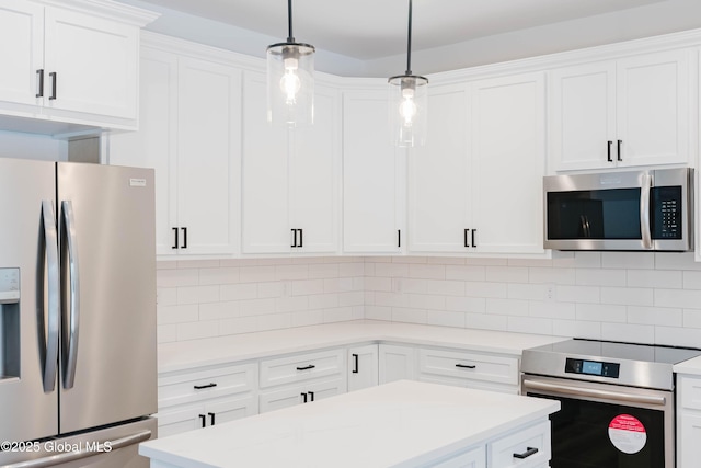 kitchen with stainless steel appliances, white cabinetry, and hanging light fixtures