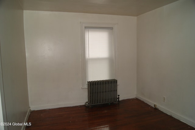 unfurnished room featuring dark hardwood / wood-style floors and radiator