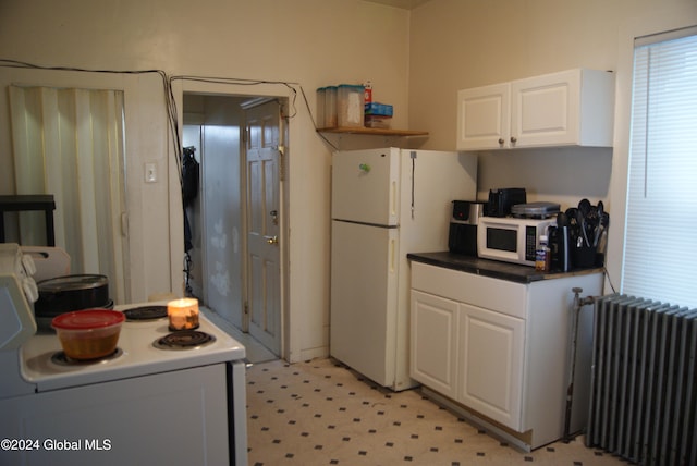 kitchen with white cabinetry, radiator heating unit, and white appliances