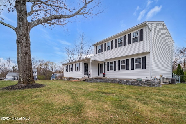 colonial-style house with a front yard and cooling unit