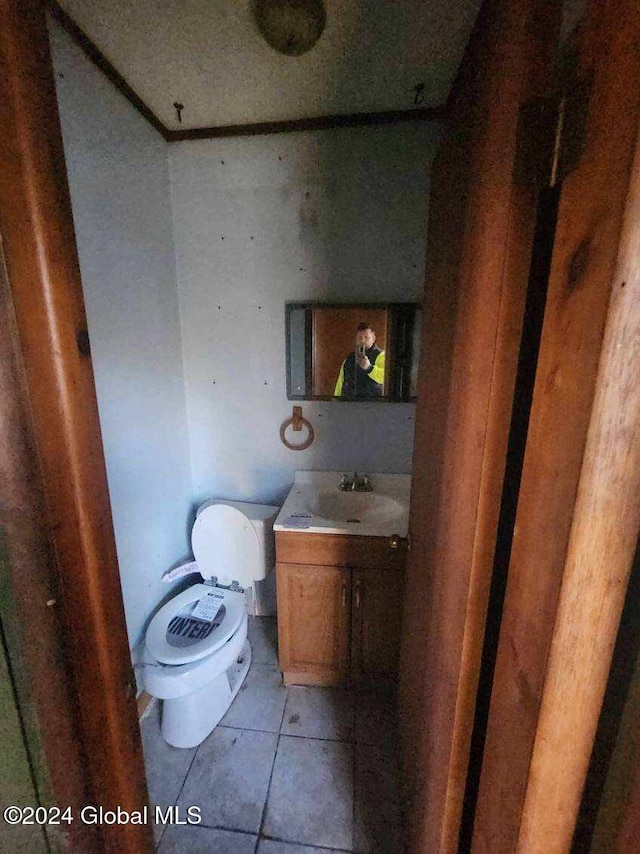 bathroom with toilet, vanity, and tile patterned floors