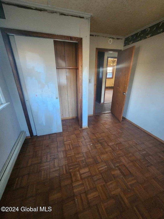 unfurnished bedroom featuring dark parquet flooring and a closet