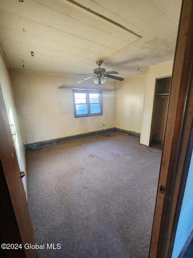 carpeted spare room with ceiling fan