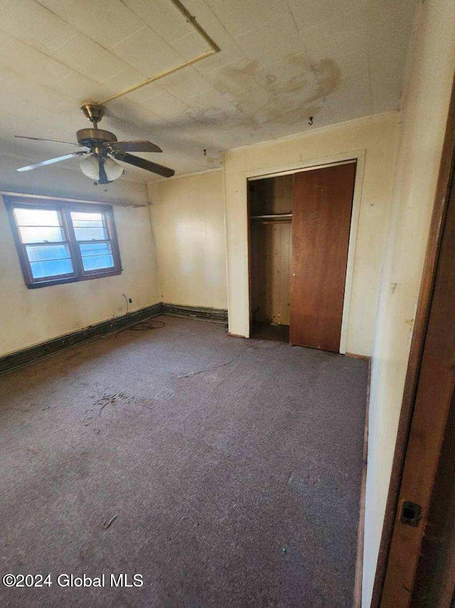 unfurnished bedroom featuring ceiling fan, carpet flooring, and a closet