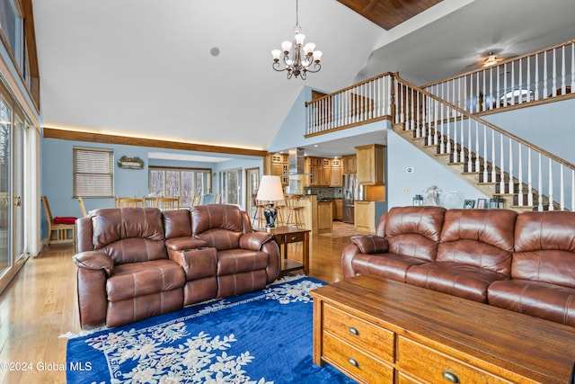 living room with an inviting chandelier, high vaulted ceiling, and hardwood / wood-style flooring