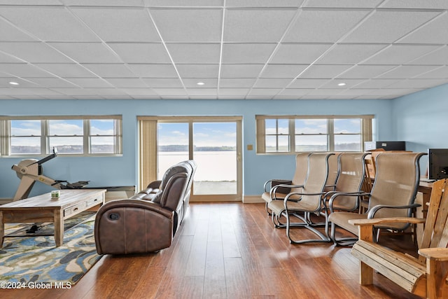 living room with a paneled ceiling, a wealth of natural light, and wood-type flooring