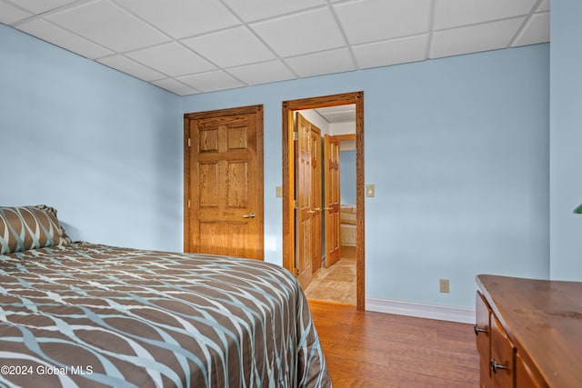 bedroom featuring hardwood / wood-style flooring and a paneled ceiling