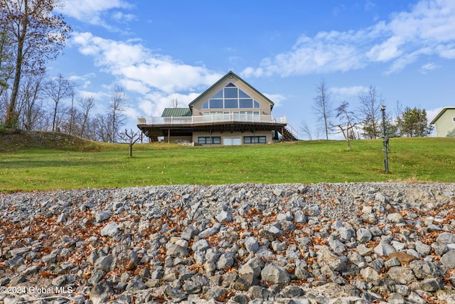 rear view of house with a yard, a rural view, and a wooden deck