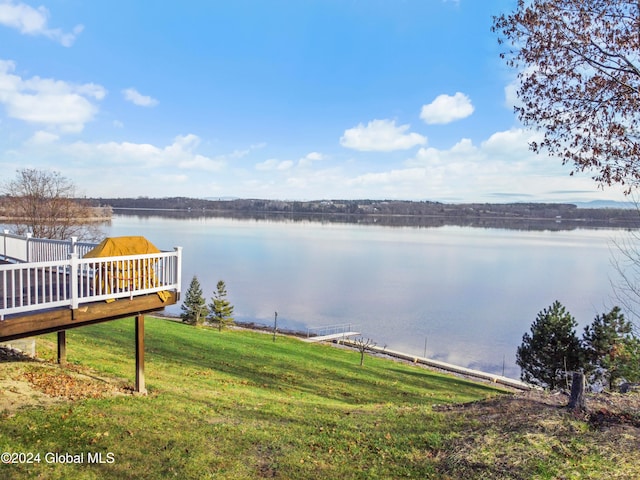 dock area with a lawn and a water view