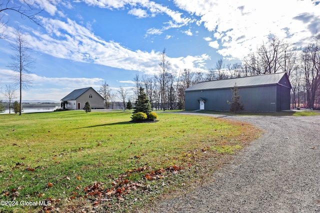 view of yard with a water view and an outbuilding