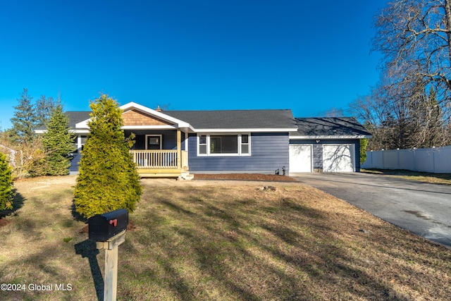 single story home with a front yard, covered porch, and a garage