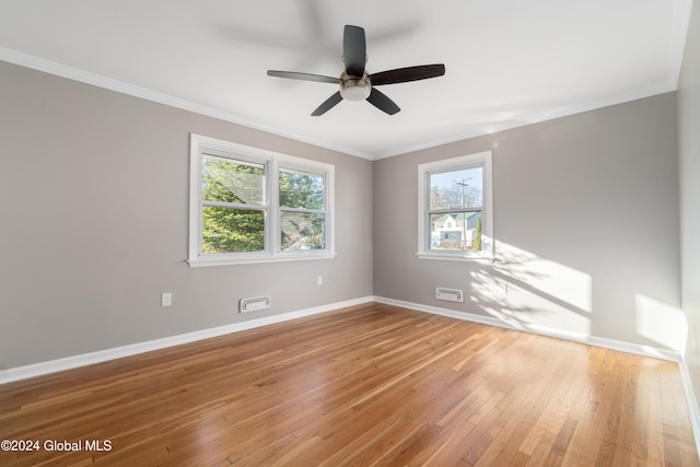 empty room with ceiling fan, wood-type flooring, and crown molding