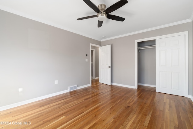 unfurnished bedroom with a closet, hardwood / wood-style flooring, ceiling fan, and ornamental molding