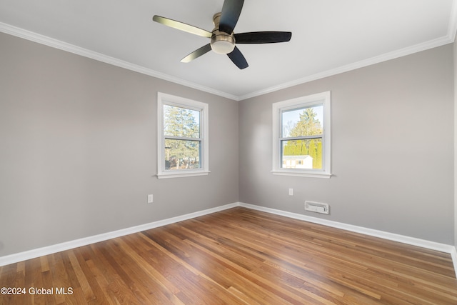 spare room featuring hardwood / wood-style floors, plenty of natural light, crown molding, and ceiling fan