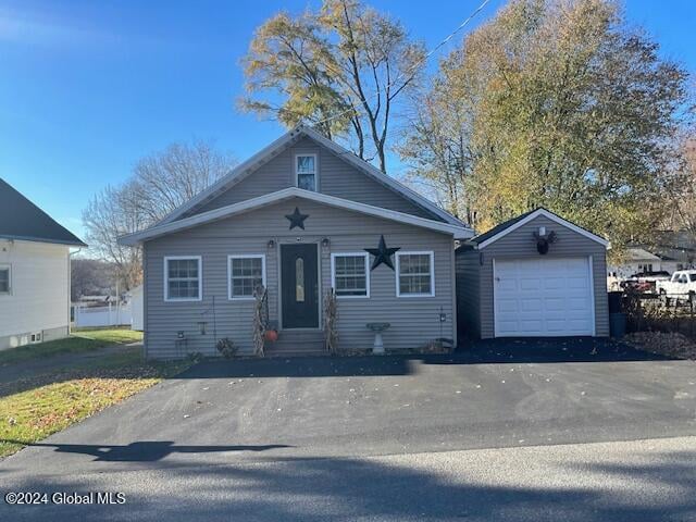 bungalow-style home with a garage and an outbuilding