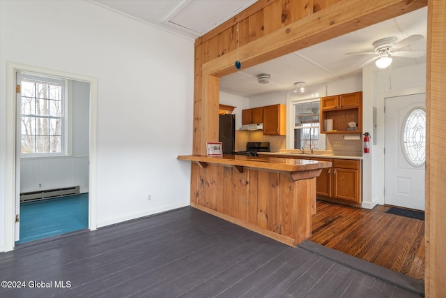 kitchen featuring kitchen peninsula, beamed ceiling, dark wood-type flooring, and a baseboard heating unit