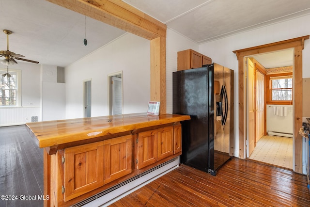 kitchen with baseboard heating, black fridge with ice dispenser, dark hardwood / wood-style floors, and wood counters