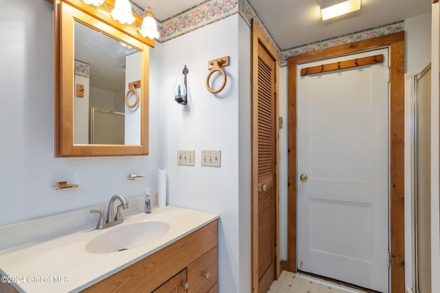 bathroom with vanity and a shower with door