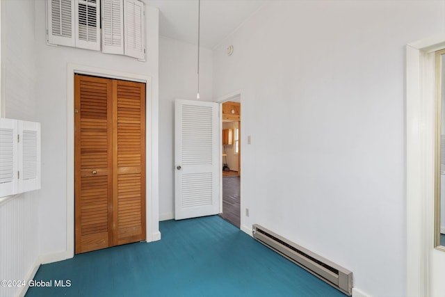 unfurnished bedroom with a closet, hardwood / wood-style floors, and a baseboard heating unit