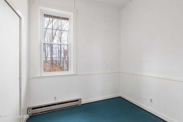 unfurnished room with baseboard heating, wood walls, and concrete flooring