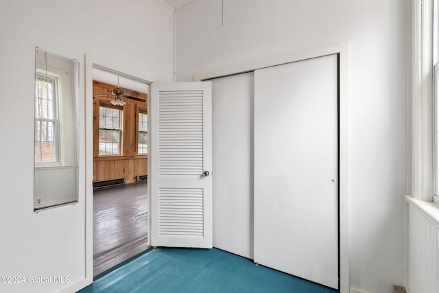 unfurnished bedroom with a closet, hardwood / wood-style floors, and a baseboard radiator