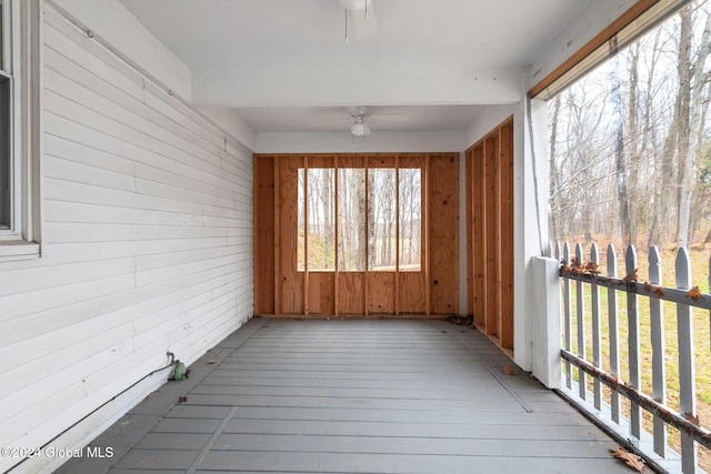 unfurnished sunroom featuring ceiling fan