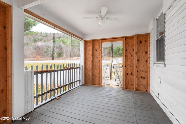 unfurnished sunroom with a wealth of natural light and ceiling fan