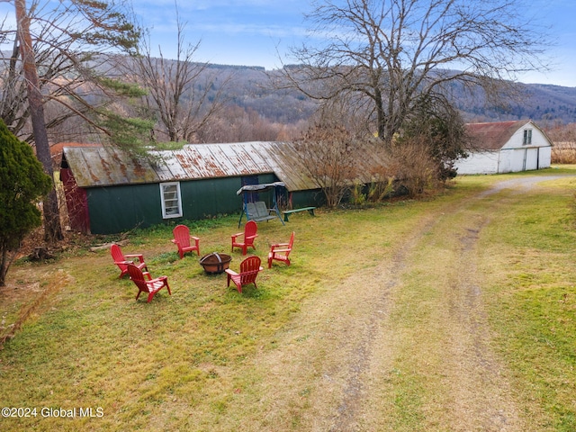 16 Main St, Worcester, NY 12064 - view of green lawn featuring a fire pit, a mountain view, an outbuilding, and a barn