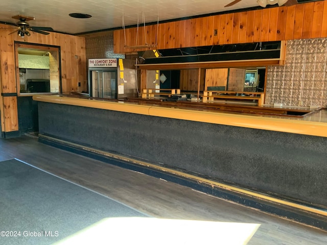 kitchen with ceiling fan and wooden walls