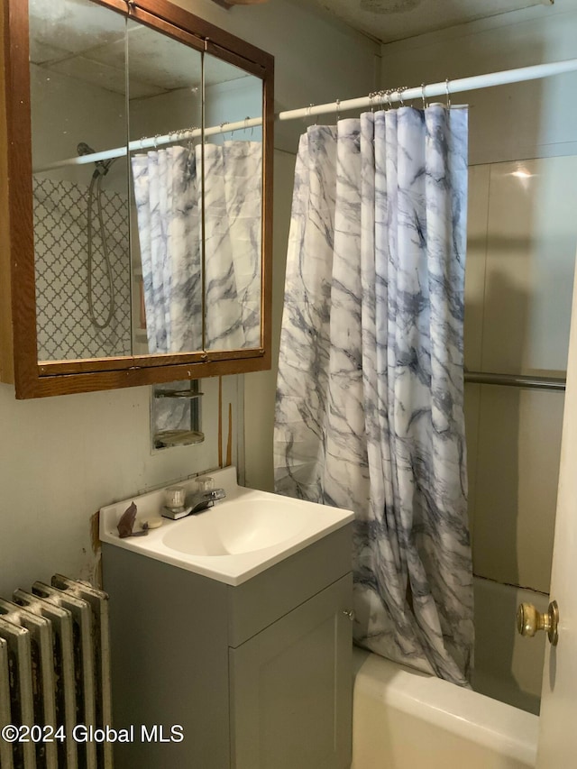 bathroom with radiator heating unit, vanity, and shower / tub combo