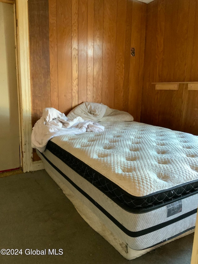 carpeted bedroom with wood walls