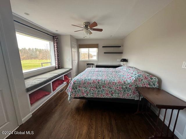 bedroom with ceiling fan and dark wood-type flooring