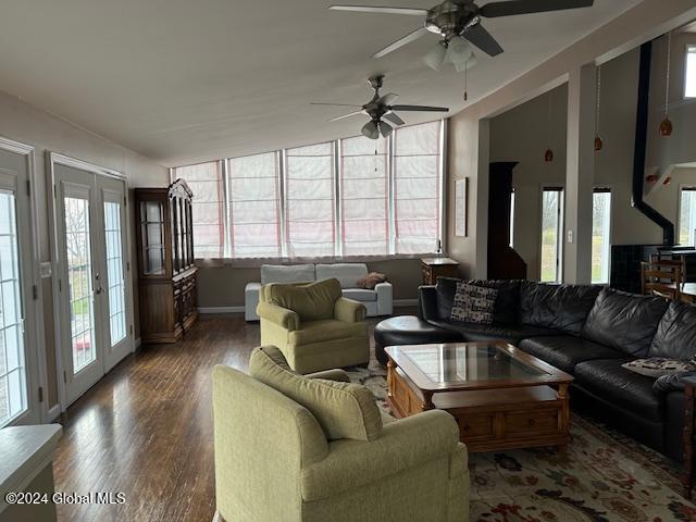 living room featuring ceiling fan, vaulted ceiling, dark wood-type flooring, and french doors