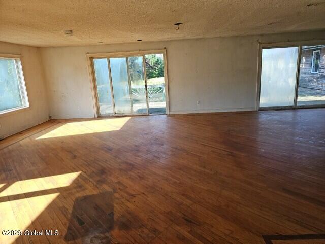 unfurnished room featuring a textured ceiling and hardwood / wood-style flooring