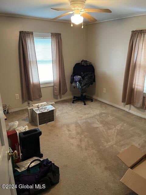 interior space featuring ceiling fan, crown molding, and light carpet