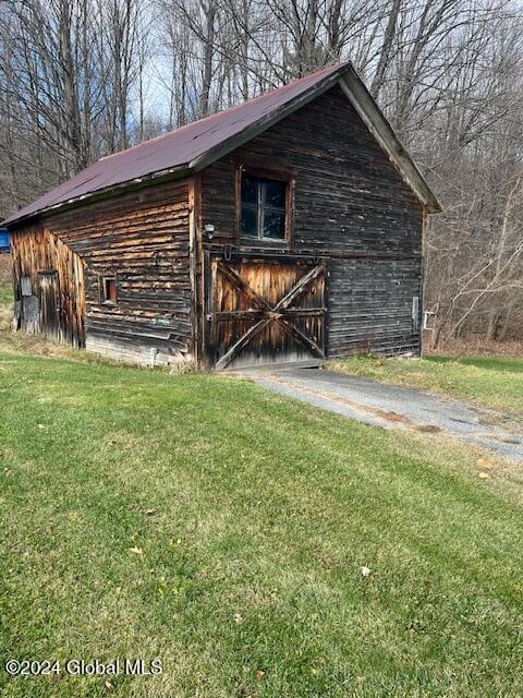 view of outbuilding featuring a yard